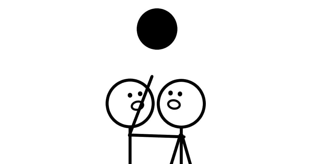 Two people are looking at a black dot and one person is pointing at it