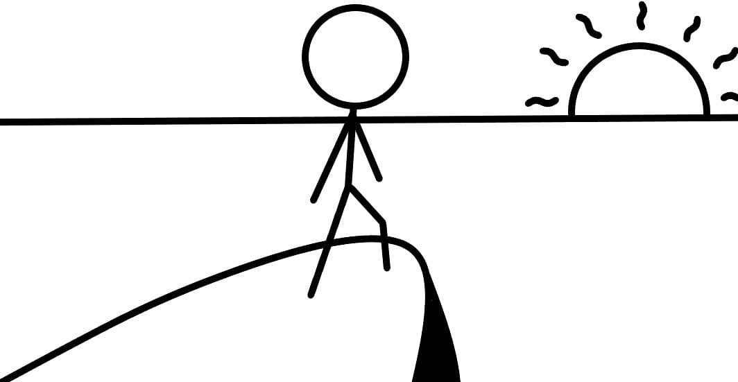 A person standing on a cliff watching a sunset